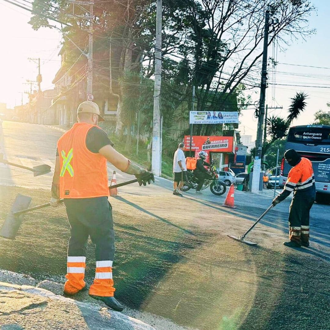 Equipe fazendo manutenção e tapa-buracos em via urbana