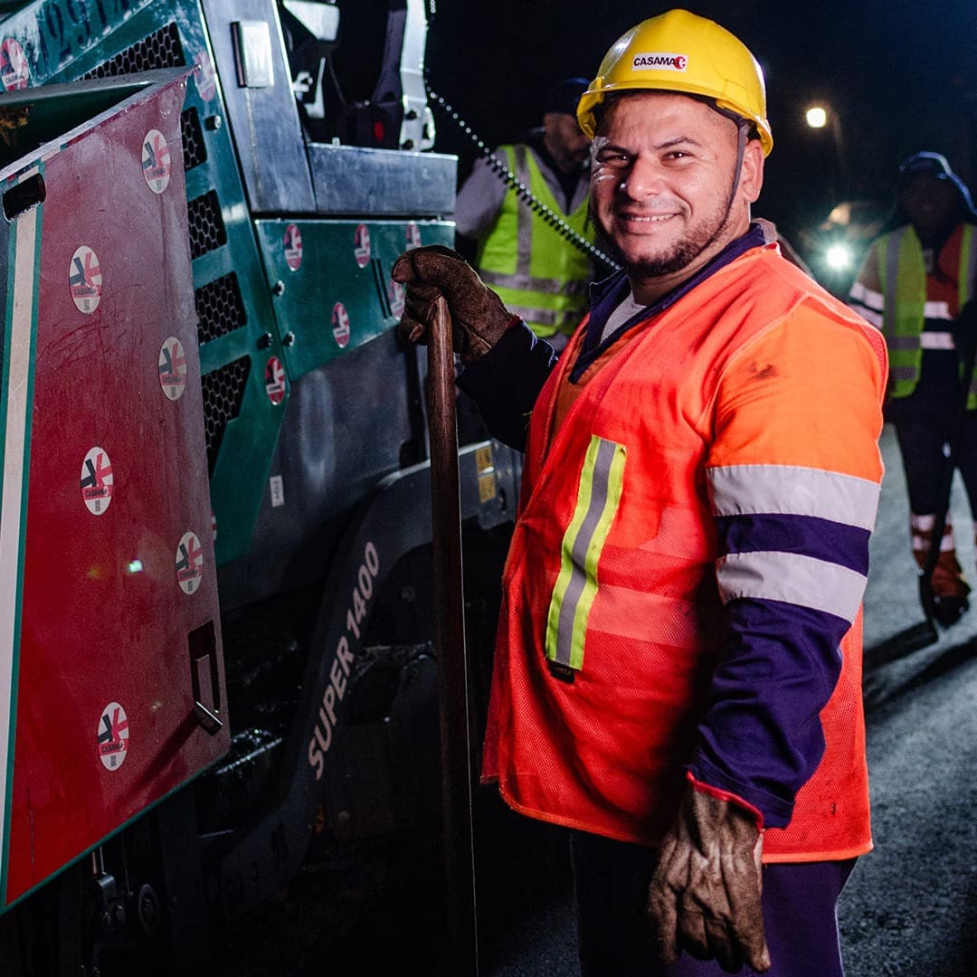 Colaborador da Casamax uniformizado e sorrindo em frente de obra