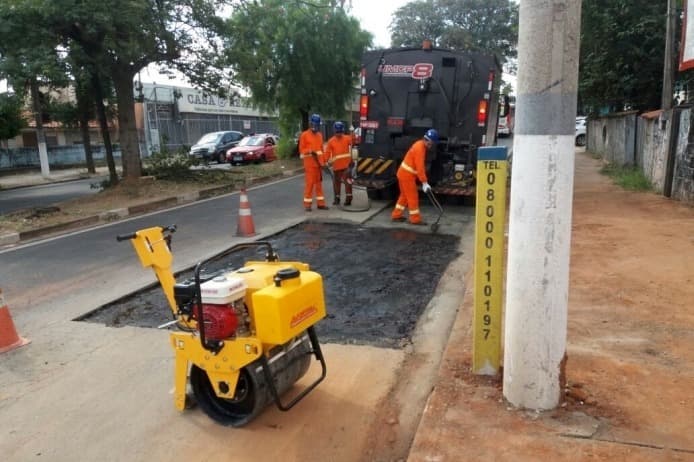 Equipe da Casamax executando tapa-buraco com rolo compactador em via urbana